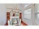 Bright dining area with glass table, hardwood floors, and elegant chandelier reflected in large mirror at 100 Demens St, Oakland, FL 34760