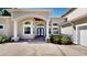 Charming home featuring a covered entryway with arched windows, and manicured landscaping at 100 Demens St, Oakland, FL 34760