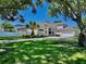 Charming exterior view of home with landscaped lawn, and a screened-in pool at 100 Demens St, Oakland, FL 34760