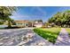 Elegant home featuring an arched entryway, manicured lawn, and a circular driveway at 100 Demens St, Oakland, FL 34760