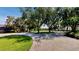 Spacious front yard featuring a circular driveway, lush green grass, and mature trees at 100 Demens St, Oakland, FL 34760