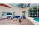 Relaxing covered patio with brick floors and comfortable seating leading to pool area at 100 Demens St, Oakland, FL 34760