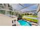 Aerial view of a private pool and spa, enclosed with a screen, in a well-maintained backyard at 100 Demens St, Oakland, FL 34760