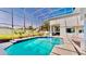 Spacious in-ground swimming pool enclosed with screened cage with views of the lush backyard at 100 Demens St, Oakland, FL 34760