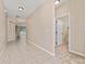 Spacious foyer with tile flooring leading to an open living area and a doorway to a bathroom at 10076 Kimble Field Way, Orlando, FL 32827