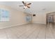 Bright living room with tile flooring, a ceiling fan, and natural light from multiple windows at 10076 Kimble Field Way, Orlando, FL 32827