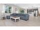 Open living room area showcasing a large sofa, wood-look tile floors, and sliding glass doors at 1073 River Otter Way, Deland, FL 32720