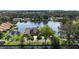 Waterfront townhomes on a calm lake, surrounded by lush greenery and palm trees on a sunny day at 1085 Island Way, Leesburg, FL 34748