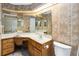 Bathroom with large mirrors, vanity area, and unique wallpaper at 1085 Island Way, Leesburg, FL 34748
