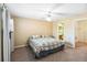 Carpeted bedroom features a ceiling fan and an open doorway to the en suite bathroom at 1085 Island Way, Leesburg, FL 34748
