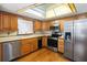 Well-lit kitchen with stainless steel appliances and wooden cabinets at 1085 Island Way, Leesburg, FL 34748