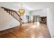Spacious living room showcasing hardwood floors, a staircase, and a stone fireplace at 1085 Island Way, Leesburg, FL 34748