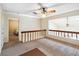 Bright loft with railing overlooking lower level and an open doorway leading to a bedroom at 1085 Island Way, Leesburg, FL 34748