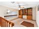 An open loft area features built in shelving and an upper railing, with a view to another floor at 1085 Island Way, Leesburg, FL 34748