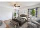 Staged main bedroom featuring a four-poster bed, ceiling fan, and bright windows at 1085 Island Way, Leesburg, FL 34748
