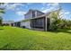 Wide green backyard with the view of the home's screened patio and exterior at 109 Lakepointe Cir, Kissimmee, FL 34743