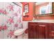 Cozy bathroom with coral walls, a classic framed mirror, and vanity at 109 Lakepointe Cir, Kissimmee, FL 34743