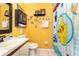The yellow, fun, bathroom has a Pokemon-themed shower curtain at 109 Lakepointe Cir, Kissimmee, FL 34743