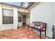 Welcoming entryway featuring a tiled patio with comfortable bench seating and a decorative front door at 109 Lakepointe Cir, Kissimmee, FL 34743