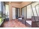 Screened patio with tiled floor, two wicker chairs and a small table at 109 Lakepointe Cir, Kissimmee, FL 34743