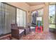 Screened patio with tiled floor, two wicker chairs and a small table at 109 Lakepointe Cir, Kissimmee, FL 34743