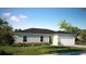 Charming single-story home featuring a well-maintained lawn, complemented by lush landscaping and a two car garage at 1114 Camden W Way, Poinciana, FL 34758