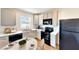 Modern kitchen featuring white cabinets, black appliances, and a breakfast nook, complemented by natural light at 1114 Camden W Way, Poinciana, FL 34758