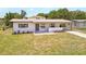 Exterior shot of home with front lawn, covered porch, updated facade, landscaping, and driveway at 1118 Roberta Ave, Orlando, FL 32825