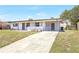 Charming home with updated facade, a covered porch, fresh landscaping, and a long driveway at 1118 Roberta Ave, Orlando, FL 32825