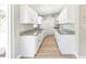 Updated kitchen with white cabinets, stainless steel appliances, granite countertops, and wood-look floors at 1118 Roberta Ave, Orlando, FL 32825