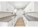 Bright kitchen with white cabinets, granite countertops, stainless steel appliances, and wood-look floors at 1118 Roberta Ave, Orlando, FL 32825