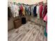 Walk-in closet with wood grain floors and an abundance of storage space with racks and shelves at 1121 Alcove Loop, The Villages, FL 32162
