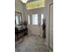Welcoming foyer with decorative mirror, table, and rug, leading to other areas of the home at 1121 Alcove Loop, The Villages, FL 32162