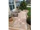 Inviting front porch with two Adirondack chairs on a paved walkway surrounded by lush landscaping at 1121 Alcove Loop, The Villages, FL 32162