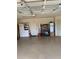 A well-lit two car garage with epoxy flooring, storage, and two entry doors at 1121 Alcove Loop, The Villages, FL 32162