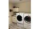 Tiled laundry room with washer and dryer, a utility sink, and overhead storage cabinets at 1121 Alcove Loop, The Villages, FL 32162