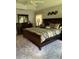 Comfortable main bedroom with a large dark wood bed frame, dresser, and neutral colored walls at 1121 Alcove Loop, The Villages, FL 32162