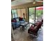 Cozy sunroom with comfortable seating, tile flooring, and views of the outdoor patio at 1121 Alcove Loop, The Villages, FL 32162