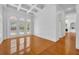 Bright living room with hardwood floors, coffered ceiling, and arched windows overlooking pool at 1158 Sweet Heather Ln, Apopka, FL 32712
