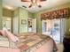Main bedroom featuring neutral carpet, patio access, and an ensuite bathroom at 118 Ventana Dr, Poinciana, FL 34759