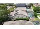 An aerial view shows home featuring solar panels, lush landscaping, screened-in pool enclosure, and neighboring homes at 1201 Shelter Rock Rd, Orlando, FL 32835