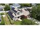A high angle aerial view shows the front facade, solar panels, walkway and lush landscaping at 1201 Shelter Rock Rd, Orlando, FL 32835