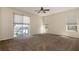 Neutral toned main bedroom featuring a ceiling fan, carpet, and sliding door to the pool at 1201 Shelter Rock Rd, Orlando, FL 32835