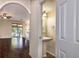 Cozy powder room with pedestal sink, complemented by hardwood flooring and an arched entryway at 1201 Shelter Rock Rd, Orlando, FL 32835