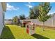 A backyard featuring lush green grass and a playhouse, perfect for activities and Gathering enjoyment at 1265 Blarney St, Minneola, FL 34715