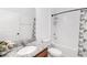 Well-lit bathroom featuring a granite countertop vanity and a shower-tub combo with patterned shower curtain at 1265 Blarney St, Minneola, FL 34715