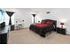 Bedroom with a large bed, dresser, vanity, and carpeted floors at 1265 Blarney St, Minneola, FL 34715