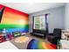 Colorful playroom featuring a rainbow wall, a black futon and a sun rug at 1265 Blarney St, Minneola, FL 34715