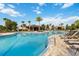 Inviting community pool area with comfortable lounge chairs and tropical palm trees for a relaxing experience at 1265 Blarney St, Minneola, FL 34715