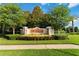Entrance to Ardmore Reserve, featuring a stone and beige sign, lush landscaping, and mature shade trees at 1265 Blarney St, Minneola, FL 34715